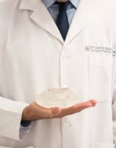 Implante mamario en la mano del cirujano